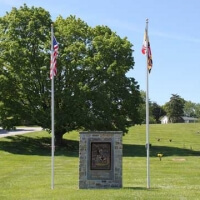 Garden of Honor monument flanked by U.S. flag and Maryland flags